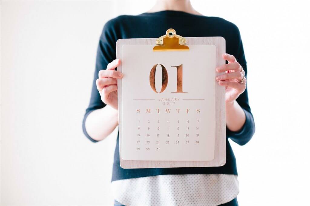 A person holding a monthly calendar